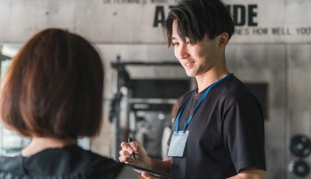 運動メニューの指導をする男性トレーナー